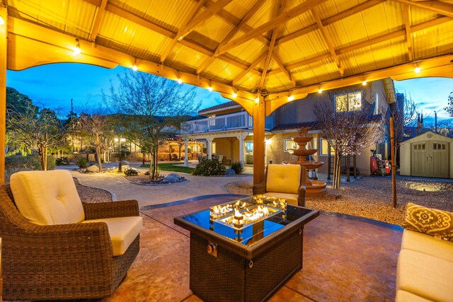 view of patio featuring a gazebo, a storage shed, an outdoor fire pit, and an outbuilding