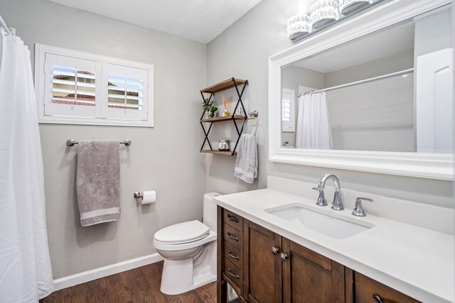 full bathroom featuring toilet, plenty of natural light, baseboards, and wood finished floors