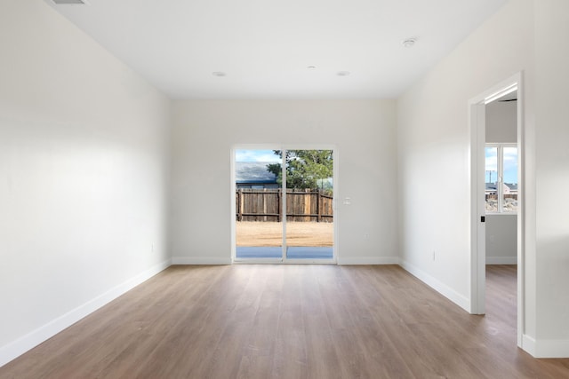 unfurnished room featuring baseboards and wood finished floors