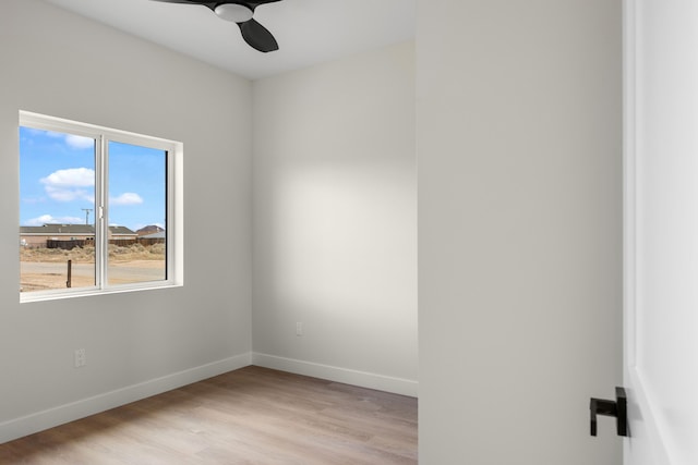 unfurnished room featuring baseboards, a ceiling fan, and light wood finished floors