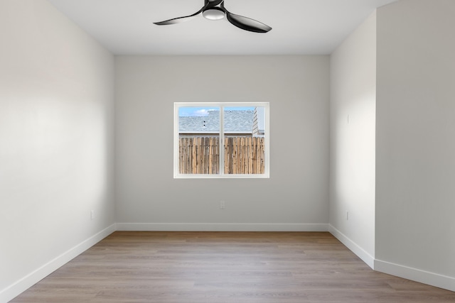 spare room featuring light wood-style floors, baseboards, and ceiling fan