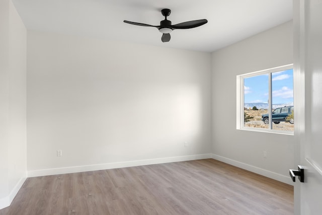 unfurnished room with a ceiling fan, wood finished floors, and baseboards