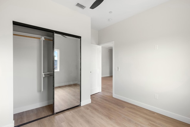 unfurnished bedroom featuring visible vents, ceiling fan, baseboards, light wood-type flooring, and a closet