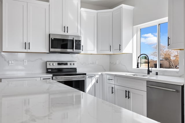 kitchen with a sink, appliances with stainless steel finishes, and white cabinetry