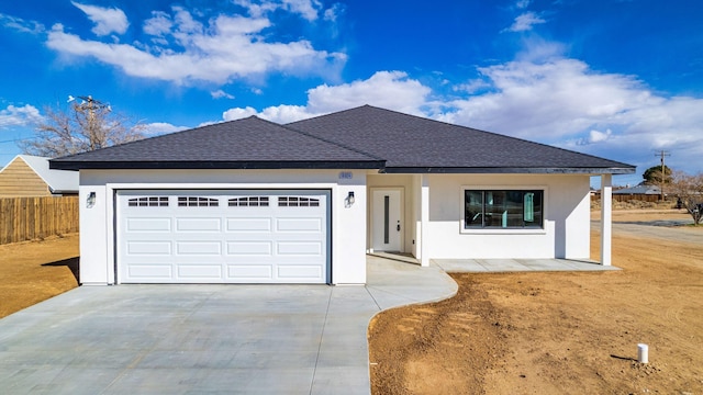 ranch-style home featuring stucco siding, driveway, a shingled roof, and fence