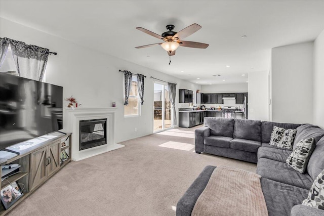 carpeted living room with ceiling fan