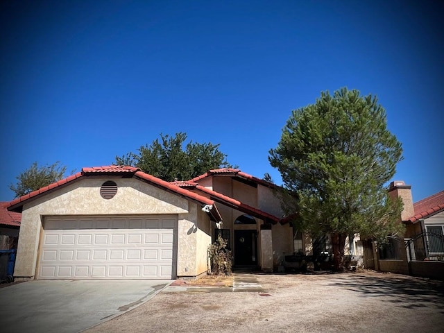 1607 E Newgrove St, Lancaster, CA 93535 - view of front of property with stucco siding, a garage, a tiled roof, and driveway