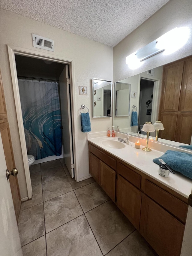1607 E Newgrove St, Lancaster, CA 93535 - full bath with toilet, a textured ceiling, vanity, and tile patterned flooring