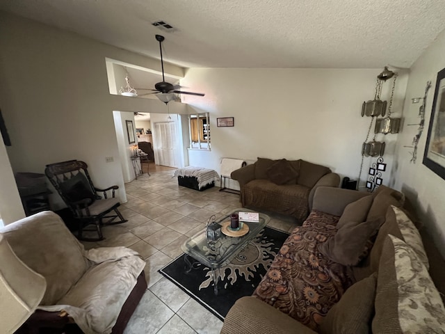 1607 E Newgrove St, Lancaster, CA 93535 - living room featuring a textured ceiling, vaulted ceiling, light tile patterned floors, and a ceiling fan