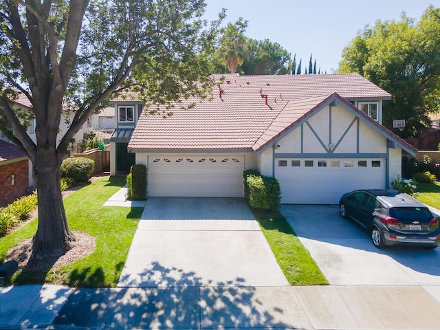 view of front of property featuring concrete driveway, stucco siding, a chimney, a tiled roof, and a front yard