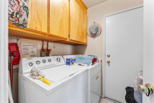 clothes washing area featuring cabinets and washer and clothes dryer