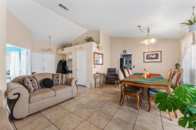 tiled living room featuring high vaulted ceiling and a chandelier