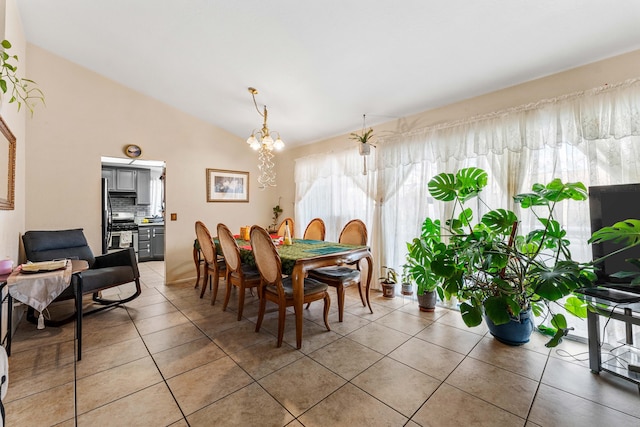 dining space featuring a notable chandelier, lofted ceiling, and light tile patterned floors