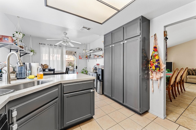 kitchen with gray cabinets, ceiling fan, and sink