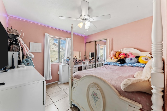 tiled bedroom with ceiling fan and a closet