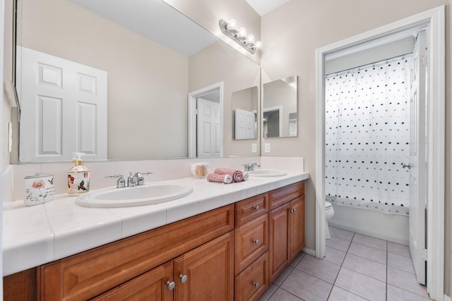 bathroom featuring toilet, double vanity, and tile patterned floors