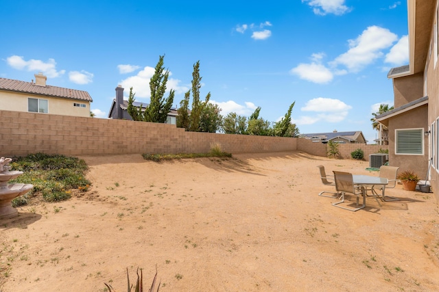 fenced backyard featuring central AC