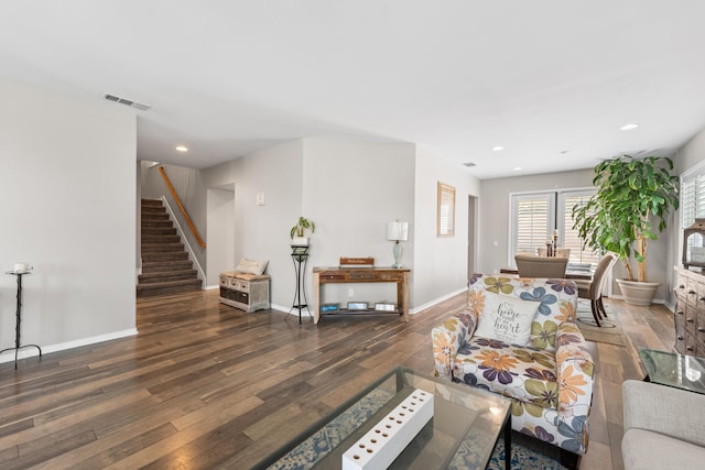 living area featuring wood finished floors, stairs, baseboards, and recessed lighting