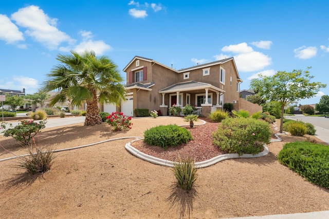 view of front facade with a porch, stucco siding, driveway, and an attached garage