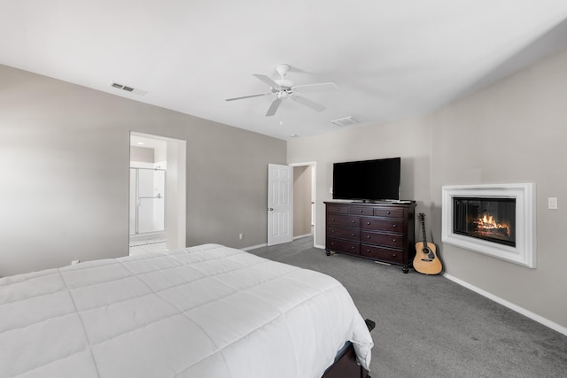bedroom with carpet, a glass covered fireplace, baseboards, ceiling fan, and ensuite bathroom