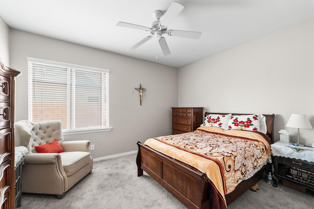 bedroom featuring light colored carpet, baseboards, and ceiling fan