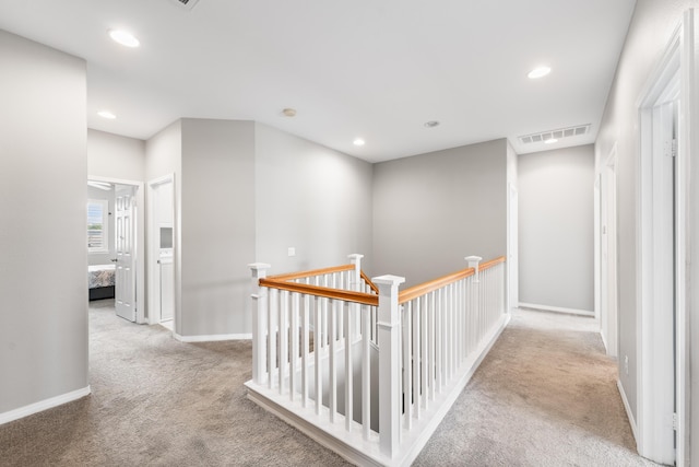 hall featuring carpet floors, an upstairs landing, recessed lighting, and baseboards