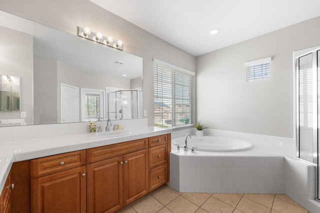 bathroom featuring a stall shower, tile patterned flooring, a bath, and vanity