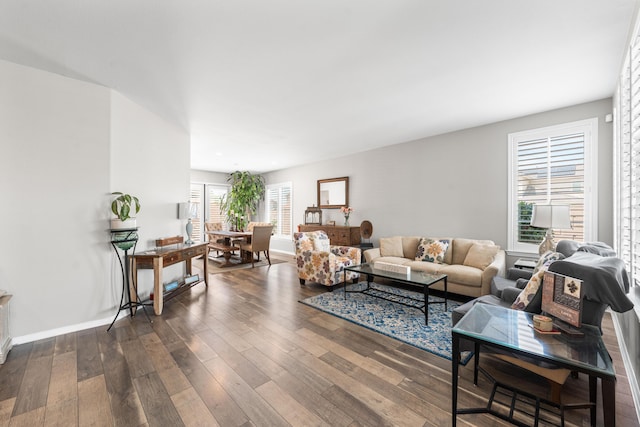 living room featuring dark wood-style flooring and baseboards