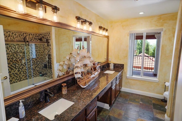 41904 Tucson Ct, Palmdale, CA 93551 - bathroom with baseboards, double vanity, toilet, combined bath / shower with glass door, and stone finish floors