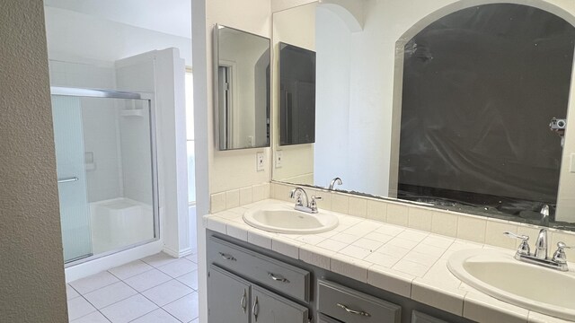 bathroom featuring tile patterned flooring, vanity, and walk in shower