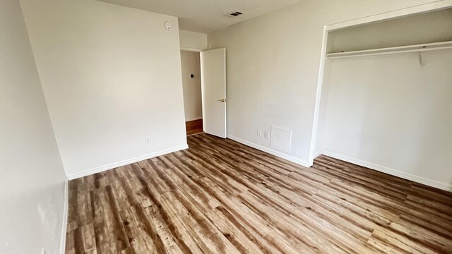 unfurnished bedroom with wood-type flooring and a closet