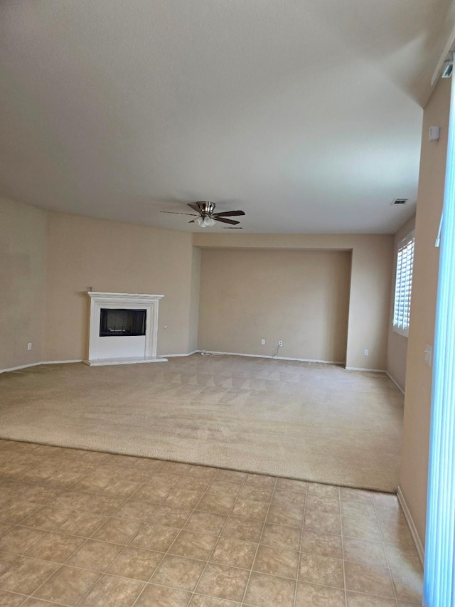 39294 Butler St, Palmdale, CA 93551 - unfurnished living room featuring light carpet, ceiling fan, baseboards, and a fireplace with raised hearth