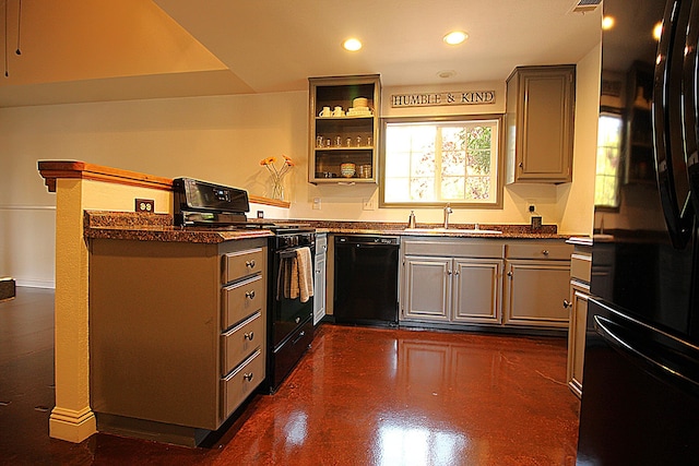 kitchen with black appliances, dark countertops, gray cabinetry, and a sink