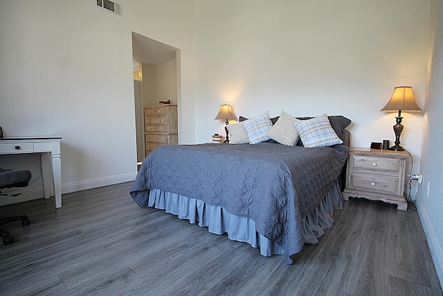 bedroom featuring baseboards, visible vents, and dark wood-type flooring