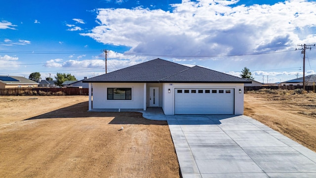 ranch-style house featuring fence, concrete driveway, roof with shingles, stucco siding, and an attached garage