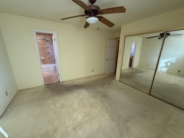 unfurnished bedroom with ensuite bath, light colored carpet, a closet, and ceiling fan