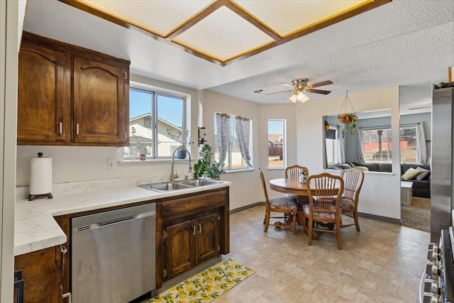 kitchen with appliances with stainless steel finishes, sink, dark brown cabinets, and a textured ceiling