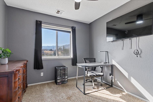 home office with ceiling fan, light carpet, and a textured ceiling