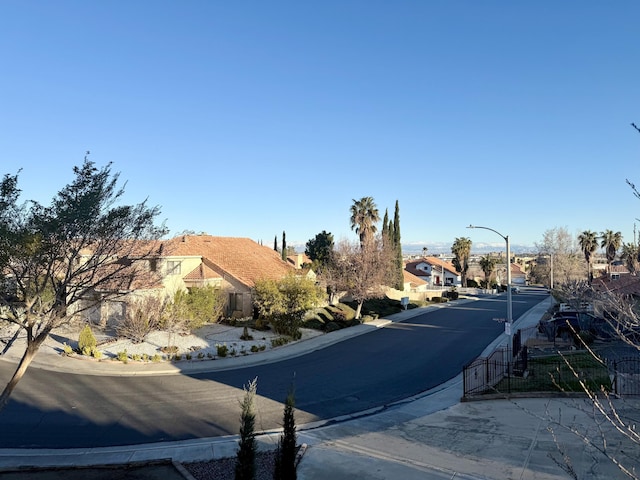 view of street featuring street lights, a residential view, and curbs