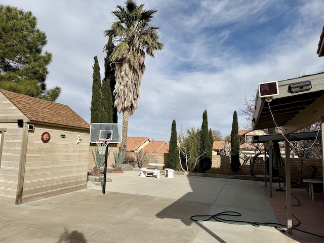 view of patio with a shed, an outdoor structure, and a fenced backyard