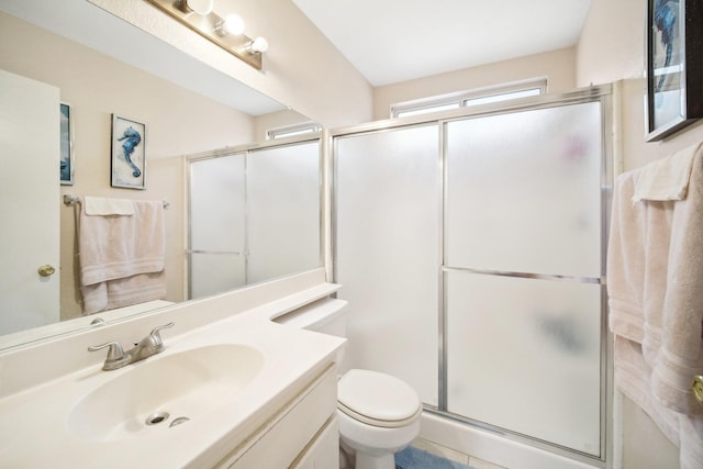 bathroom with toilet, a shower stall, and vanity