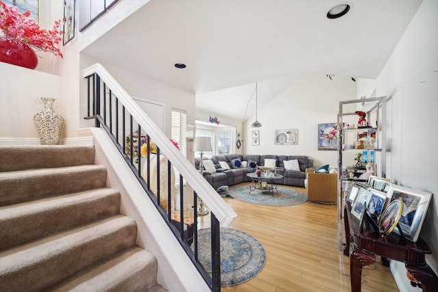 living room featuring high vaulted ceiling, stairway, wood finished floors, and recessed lighting