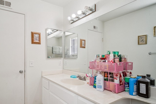 bathroom with visible vents, a sink, and double vanity