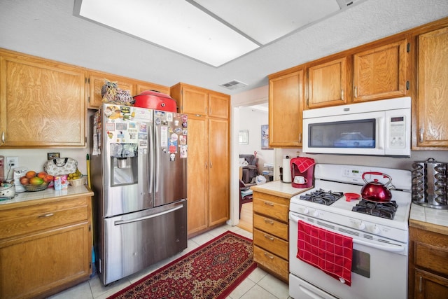 kitchen with light tile patterned floors and white appliances