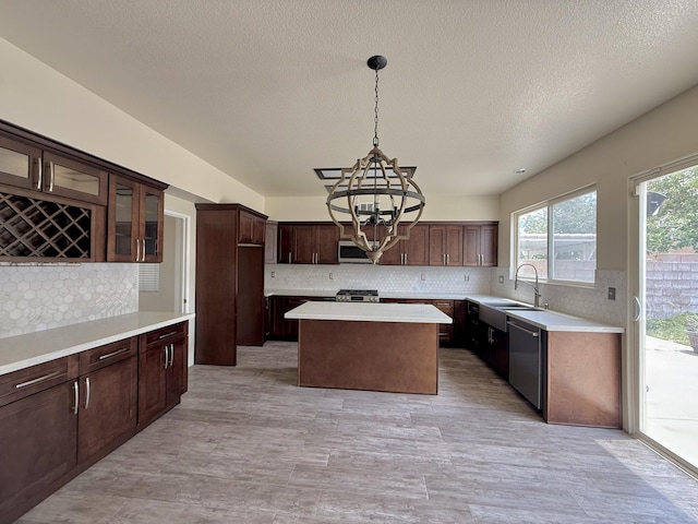 5604 Kingman Dr, Palmdale, CA 93552 - kitchen with stainless steel appliances, a chandelier, decorative backsplash, a center island, and a textured ceiling