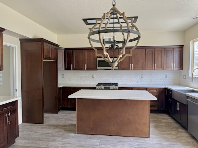 5604 Kingman Dr, Palmdale, CA 93552 - kitchen featuring a chandelier, a sink, stainless steel appliances, light countertops, and a textured ceiling