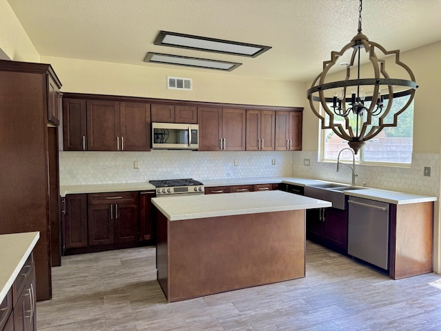5604 Kingman Dr, Palmdale, CA 93552 - kitchen with appliances with stainless steel finishes, a sink, a chandelier, light countertops, and decorative backsplash