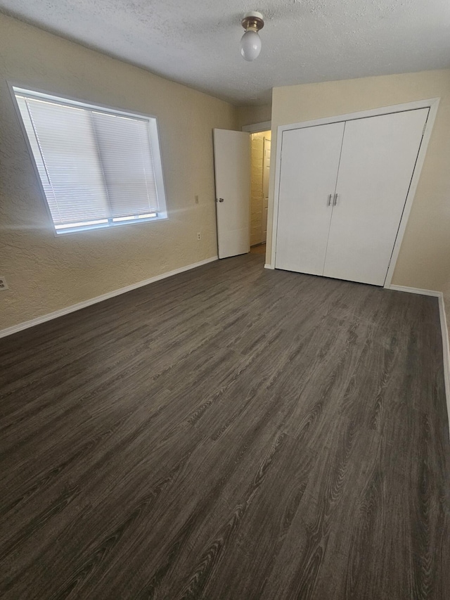 30650 233rd St, Llano, CA 93544 - unfurnished bedroom featuring dark wood-type flooring, baseboards, and a textured ceiling