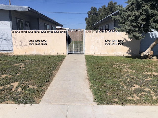 view of gate with a lawn