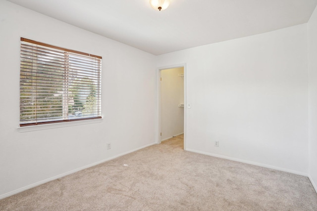 carpeted empty room with baseboards